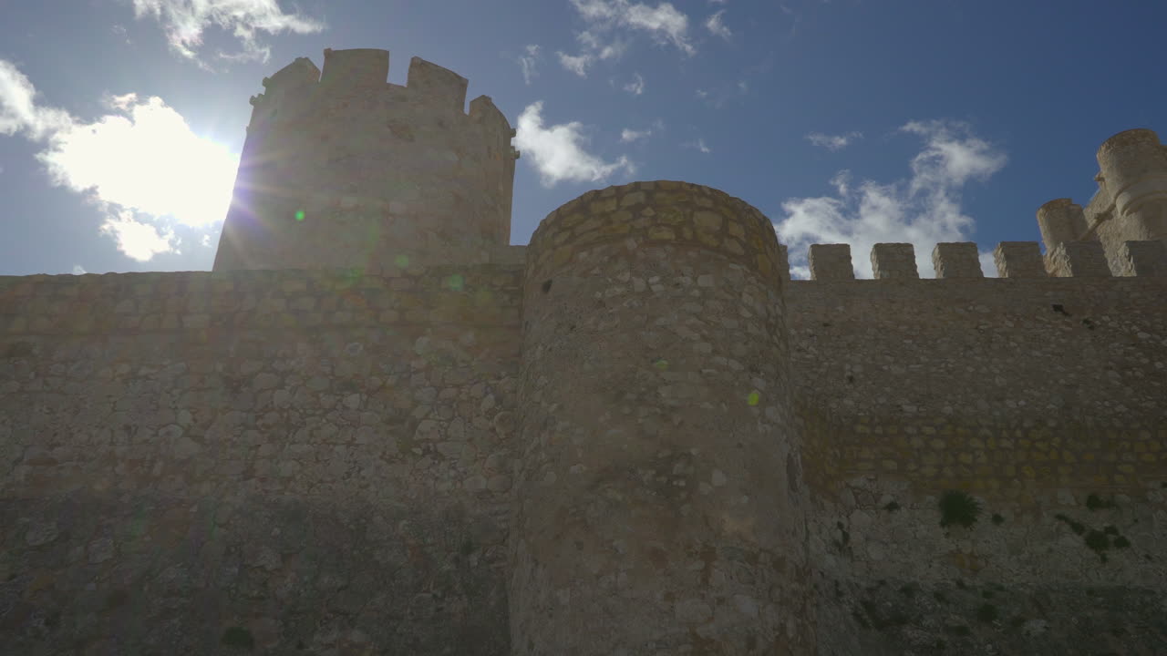 A low-angle panning view of a castle huge walls, Spain.