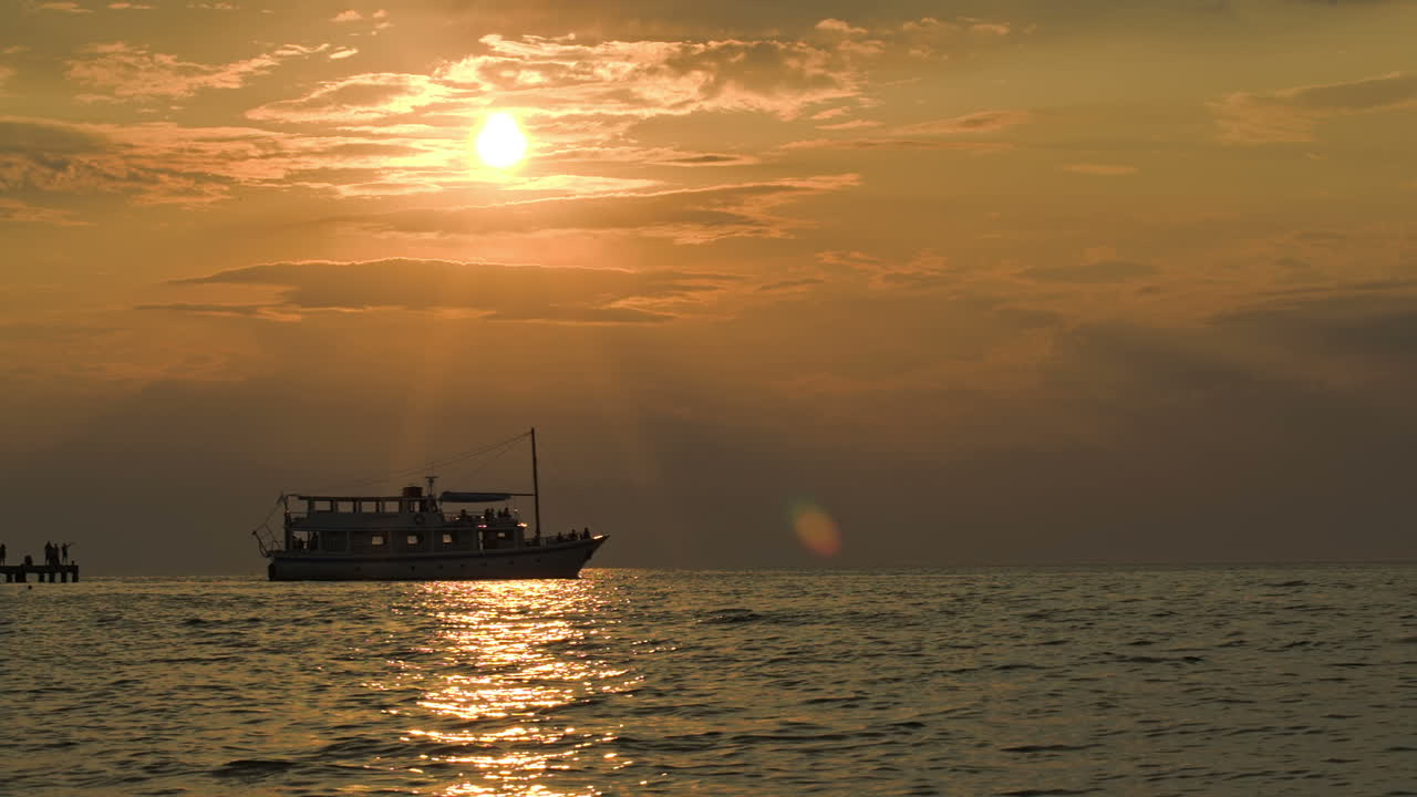 Tourist ship leaving pier at sunset