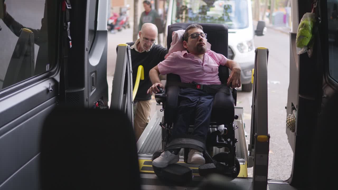 Homem em cadeira de rodas motorizada entrando em van acessível com assistência
