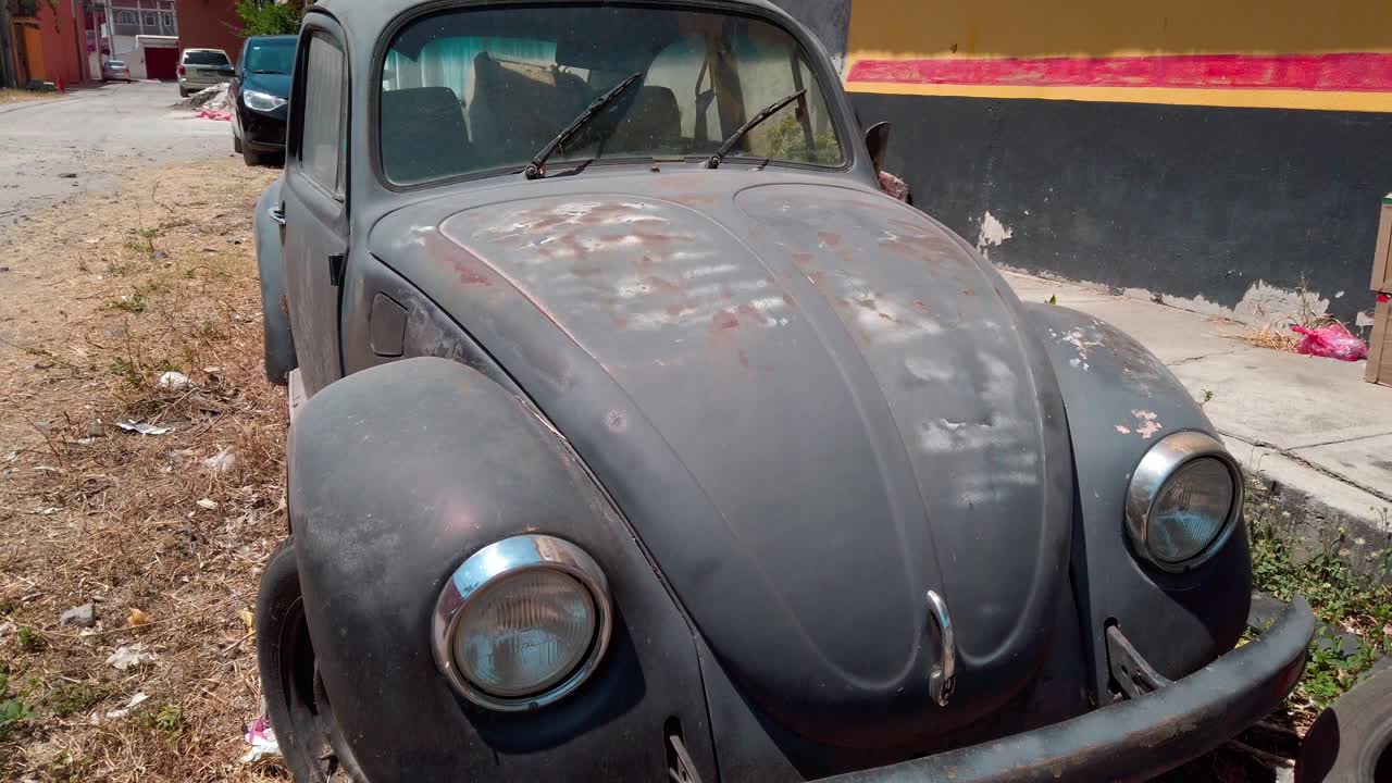 Handheld shot of old black car Volkswagen Beetle during the day, outdoor, medium shot