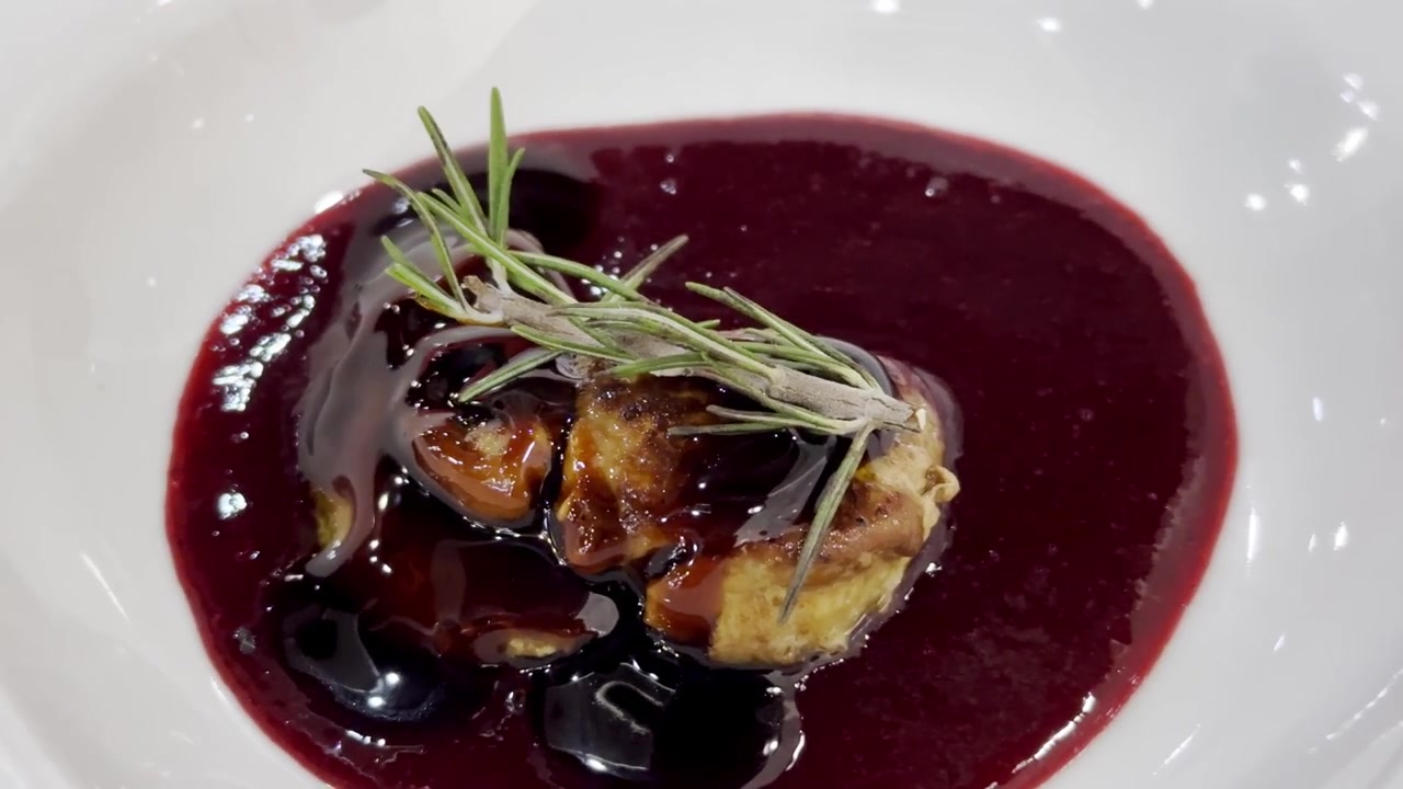 Nærbilde av pannestekt foie gras-biff toppet med rik gourmetsaus, som viser elegant presentasjon og luksuriøs finere matlaging.