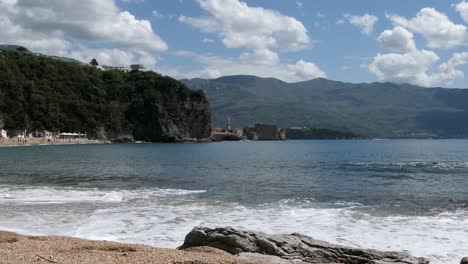 Waves-crashing-gently-on-sand-on-beach,-reveal-shot,-Southern-Europe