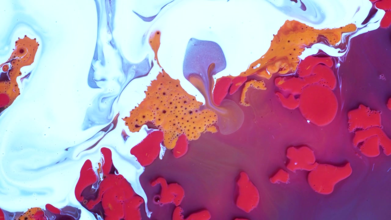 Gocce di inchiostro vibranti rosa, viola e giallo che si espandono e si mescolano in un fluido bianco. Formazione organica cellulare ad alta energia catturata con una vista dall'alto per effetti visivi artistici sperimentali