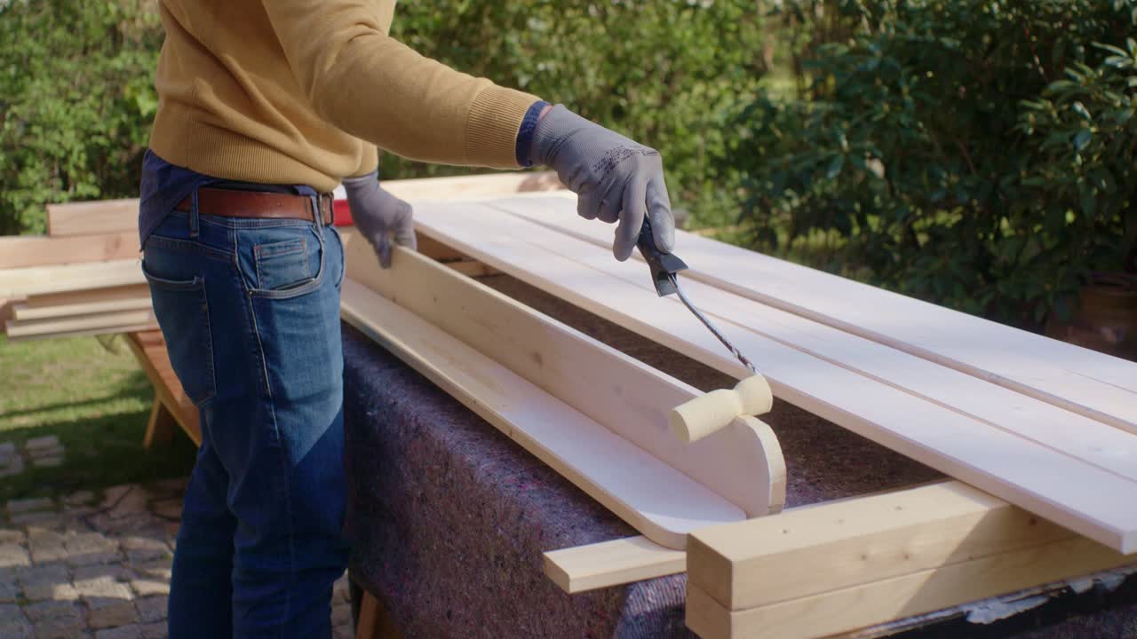 L'artigiano dipinge il bordo del pezzo di legno