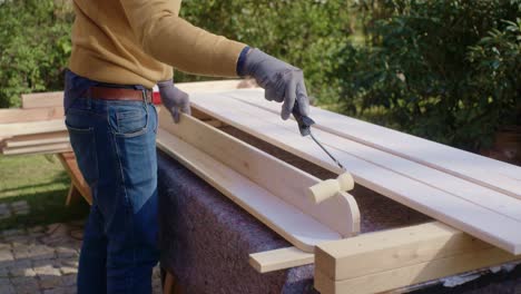 el artesano pinta el borde de la pieza de madera