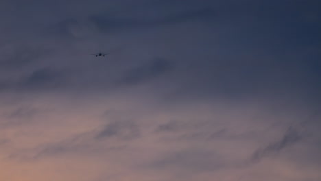 avión volando en un cielo nublado al atardecer