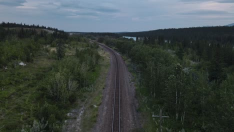 Larga-Y-Sinuosa-Vía-De-Tren-En-El-País-De-Kananaskis-Durante-La-Hora-Azul-En-Alberta,-Canadá