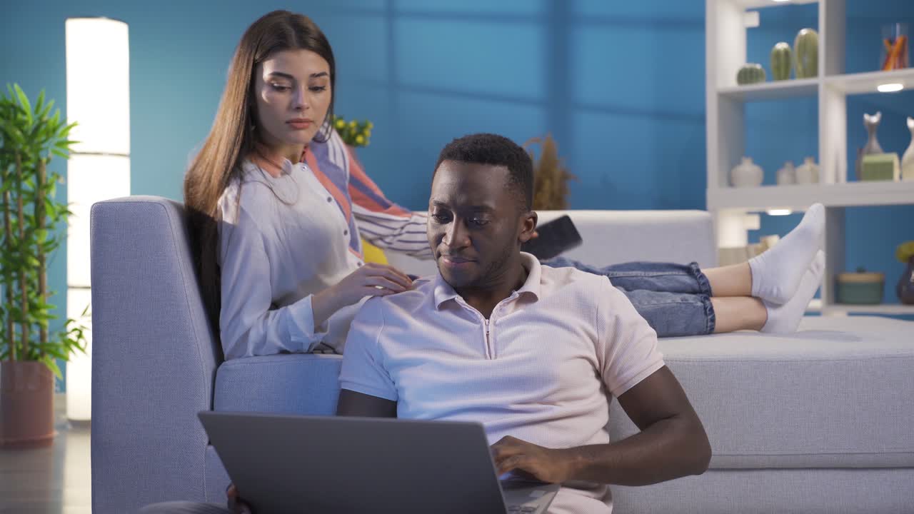 Happy multiethnic married couple spending happy time together in their home.
