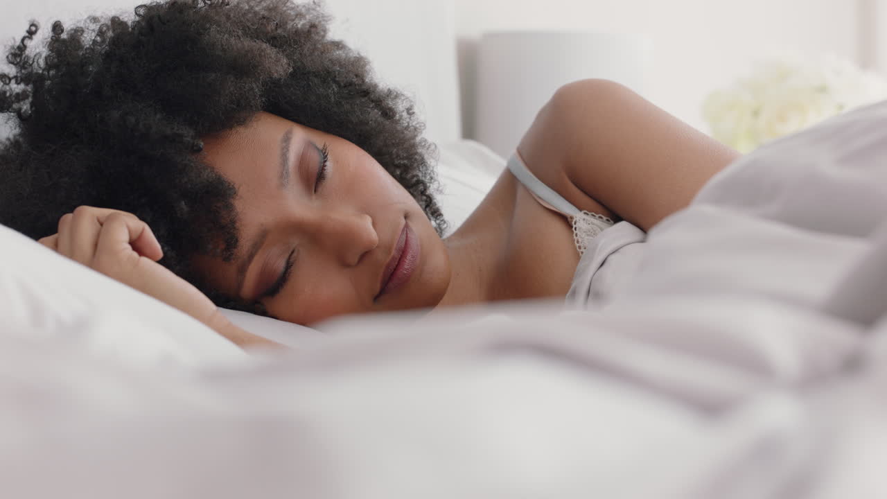 hermosa mujer afroamericana despertando en la cama después de un sueño reparador sonriendo feliz lista para el nuevo día