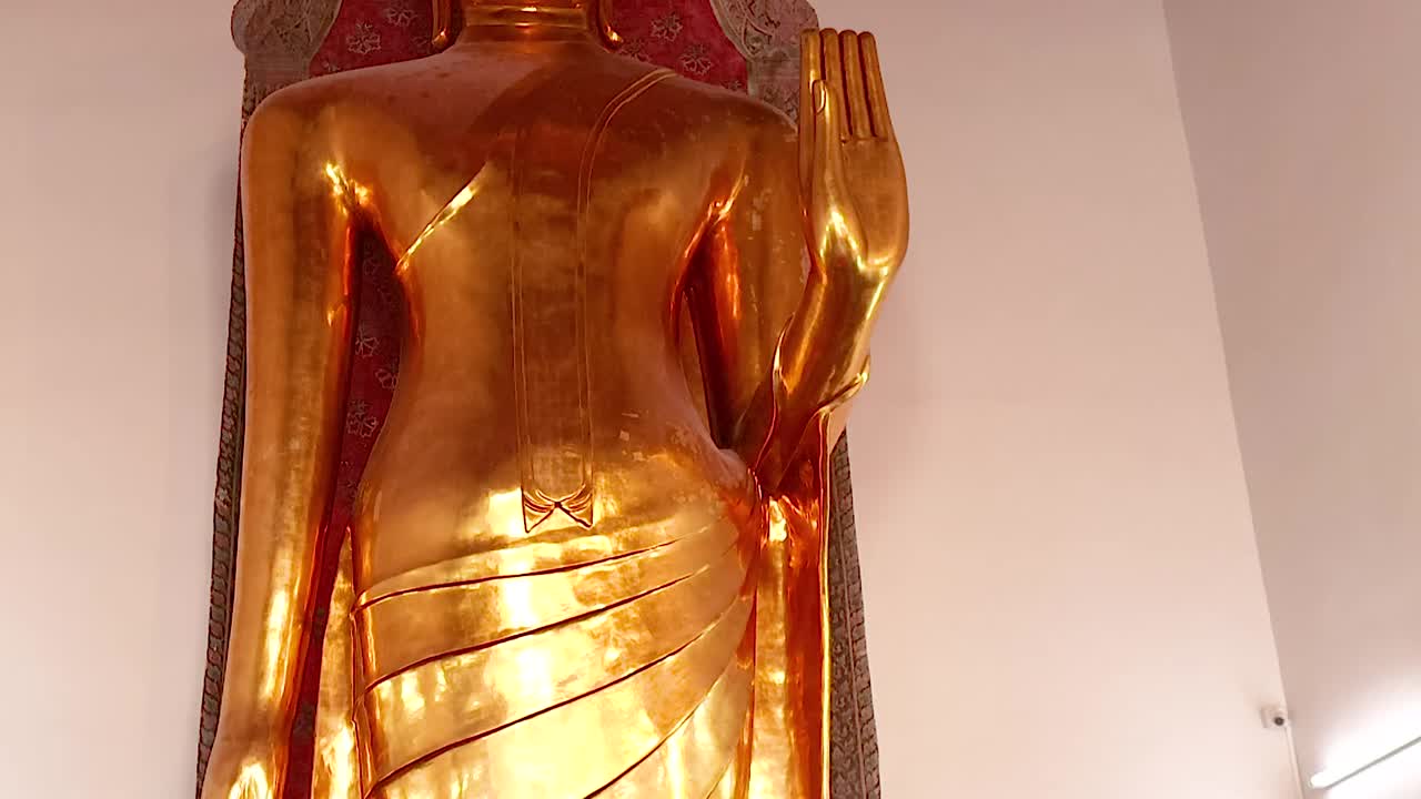 Close-up views of a golden Buddha statue surrounded by pink flowers and ornate details.