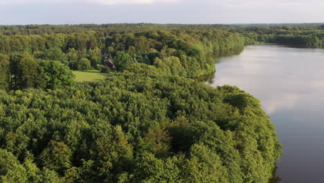 Airial-view-over-lake-Luetjensee,-lakeshore,-landscape-and-surrounding-forest