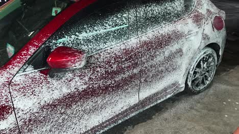 washing a red car with foam