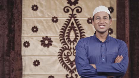 happy muslim man standing crossed hands with copyspace