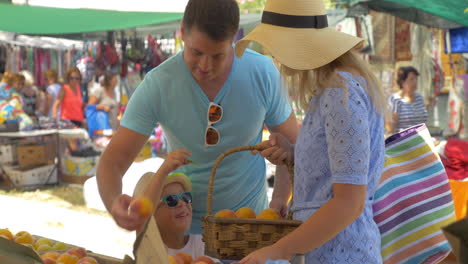 Familie-Wählt-Pfirsich-Und-Spricht-Mit-Einem-Lächeln-Auf-Dem-Outdoor-Markt-In-Thessaloniki,-Griechenland