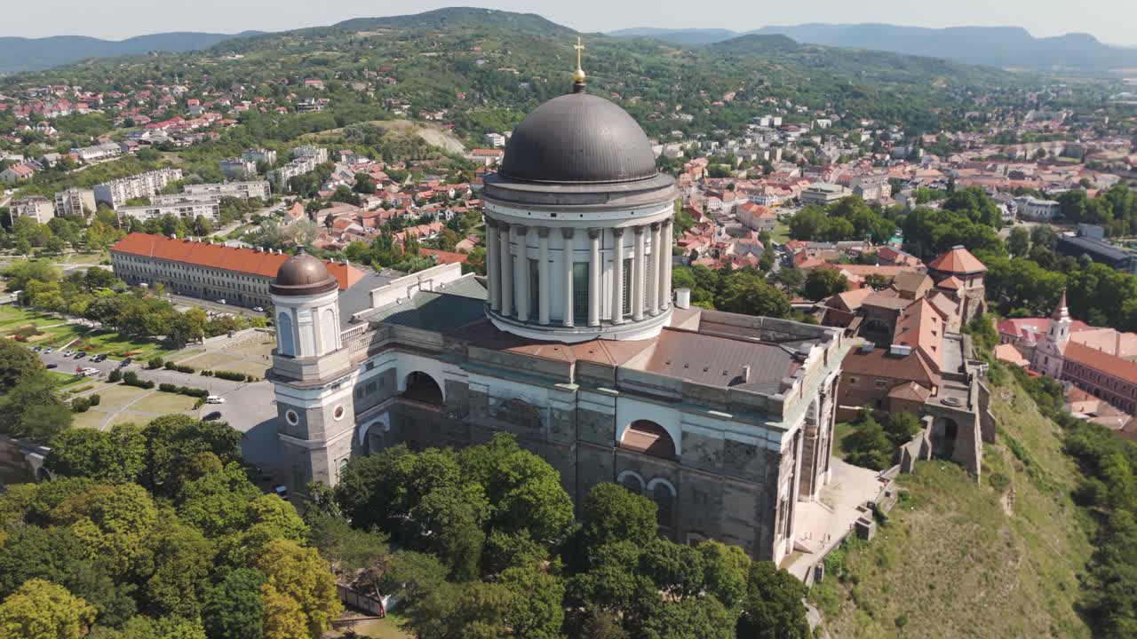 Aerial view of the Esztergom Basilica, the largest church in Hungary, dominating the cityscape on a sunny day. Orbit Motion Shot