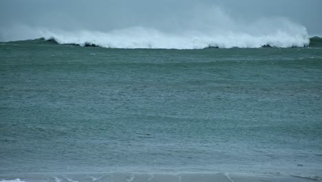 cámara lenta del tsunami acercándose al surfista irreconocible