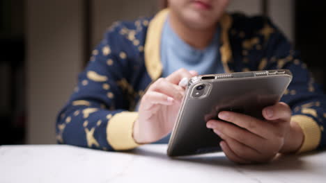 primer plano de un individuo garabateando y escribiendo algunas notas usando una tableta electrónica portátil y un bolígrafo