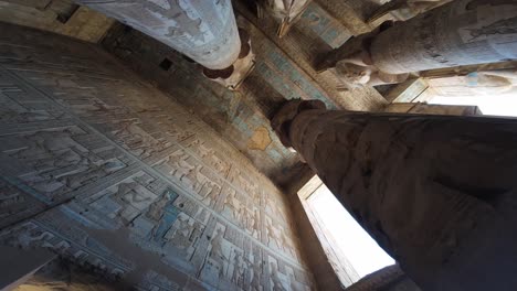 looking up at ancient columns and ceiling of dendera temple interior