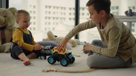 nice kids sharing toy cars on carpet. amazing kids playing together indoors.