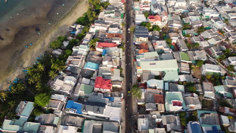 aerial, densely packed village houses next to beach coast in mui ne, vietnam