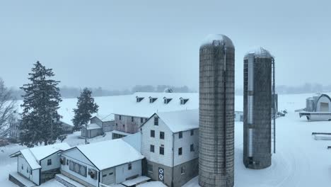 american farm house with silo storage in winter snow