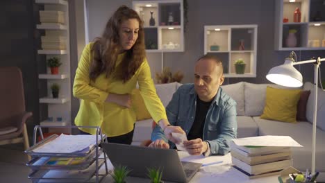 una pareja casada discutiendo sobre deudas y problemas financieros.