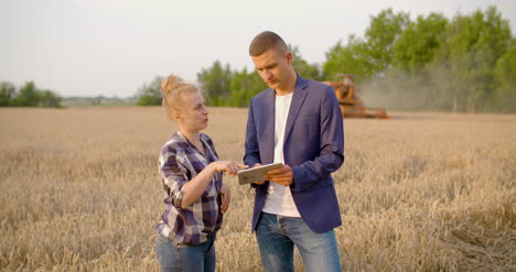 Landwirtschaft-Weibliche-Und-Männliche-Bauern,-Die-Während-Der-Ernte-Am-Weizenfeld-Sprechen