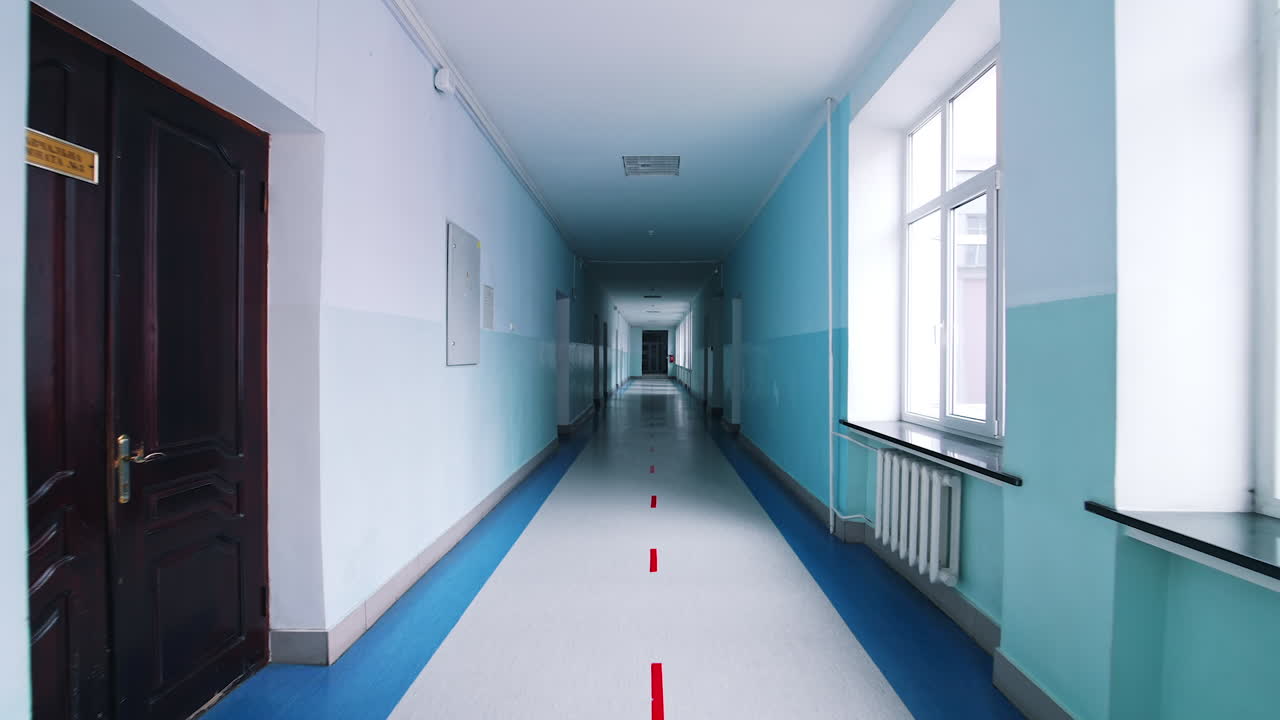 Modern hallway in educational center. Long corridor in blue color with doors and large windows in the university.