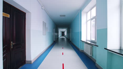 modern hallway in educational center. long corridor in blue color with doors and large windows in the university.