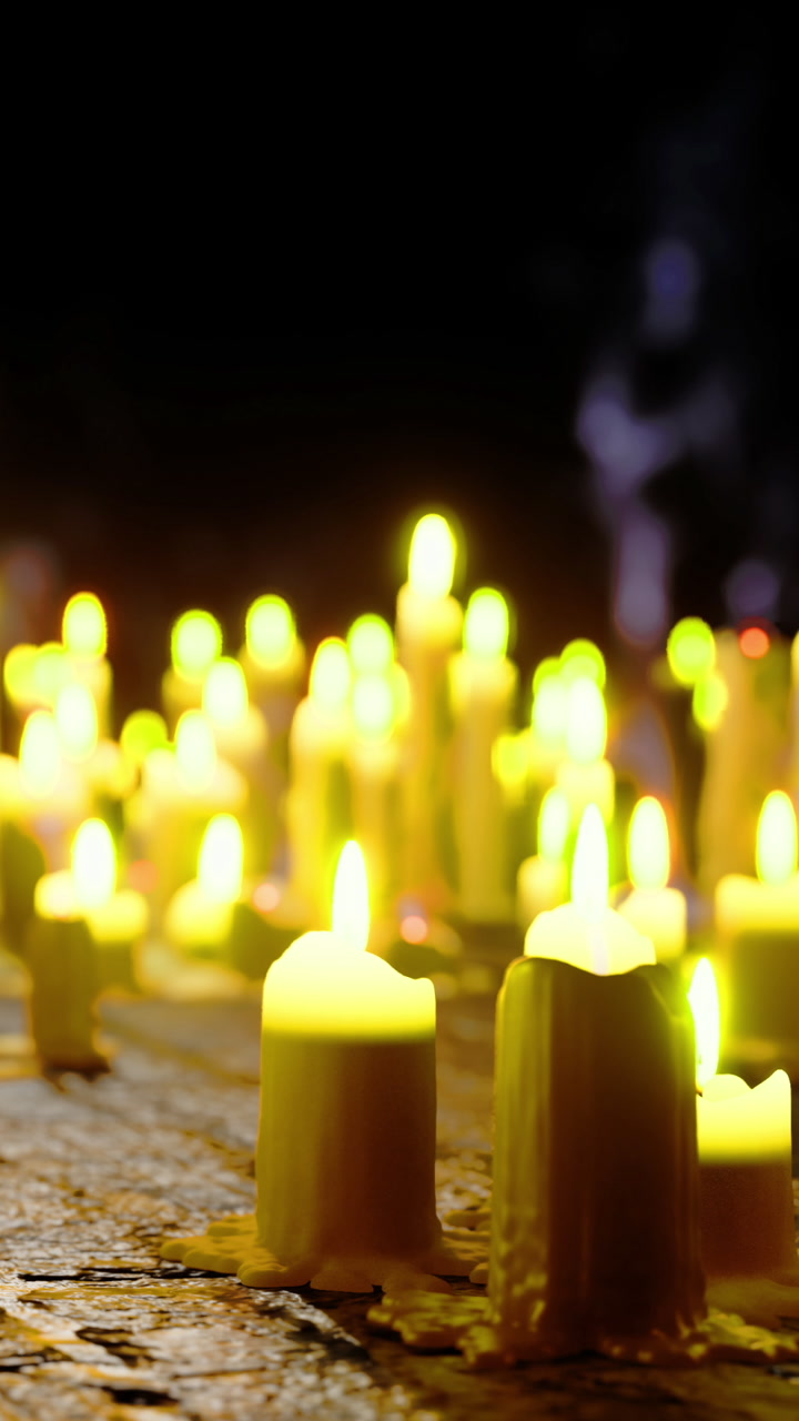 Many candles glow softly on a dark background during an evening gathering