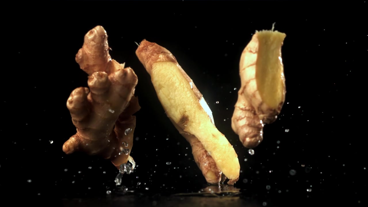 Fresh Ginger Root Falling and Splashing Water in Slow Motion