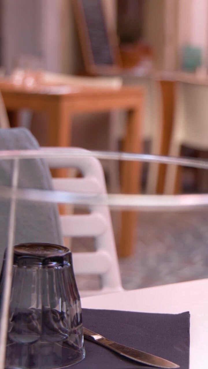 Primo piano di una tavola da bistrò apparecchiata con bicchieri e tovaglioli e sfondo con bokeh morbido