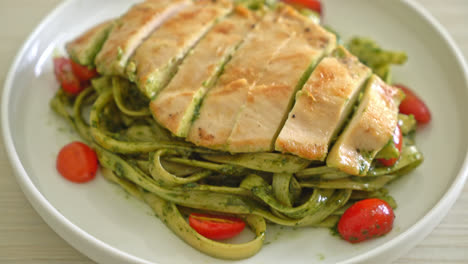 homemade fettuccine spaghetti pasta in pesto sauce with grilled chicken