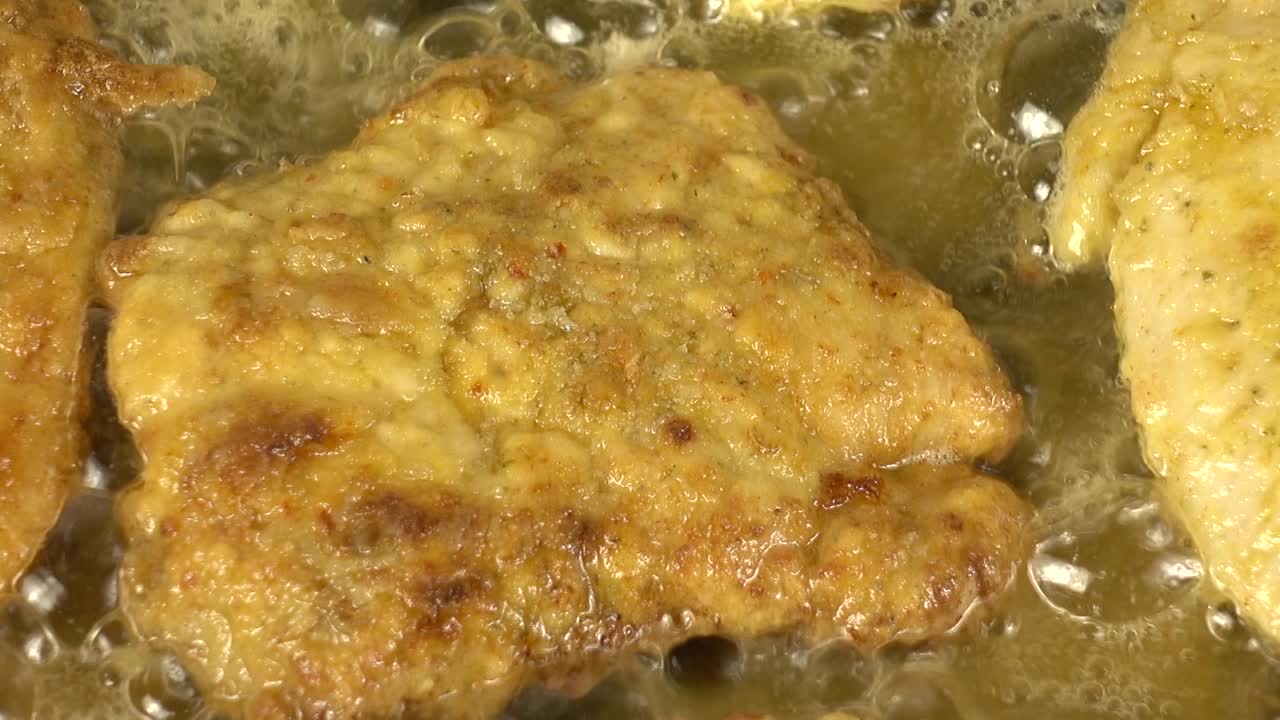 Preparazione di una cotoletta di pollo su una padella in ghisa