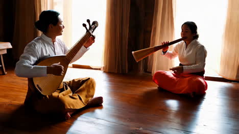 two people playing traditional musical instruments indoors