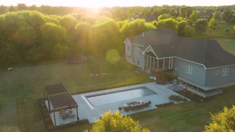 drone view of suburban home with new fiberglass pool and patio at golden sunset