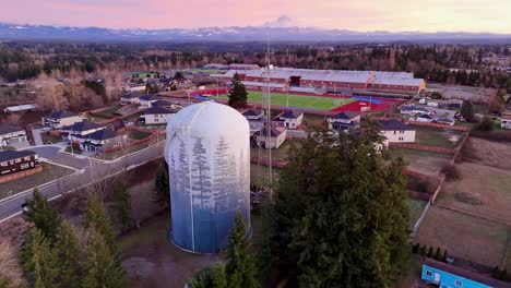 Aerial-video-circling-a-water-tower-during-sunset-in-Auburn,-Washington