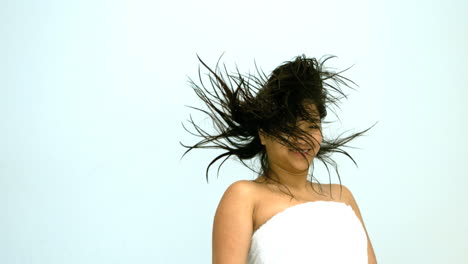 mujer sonriente saltando en una toalla blanca