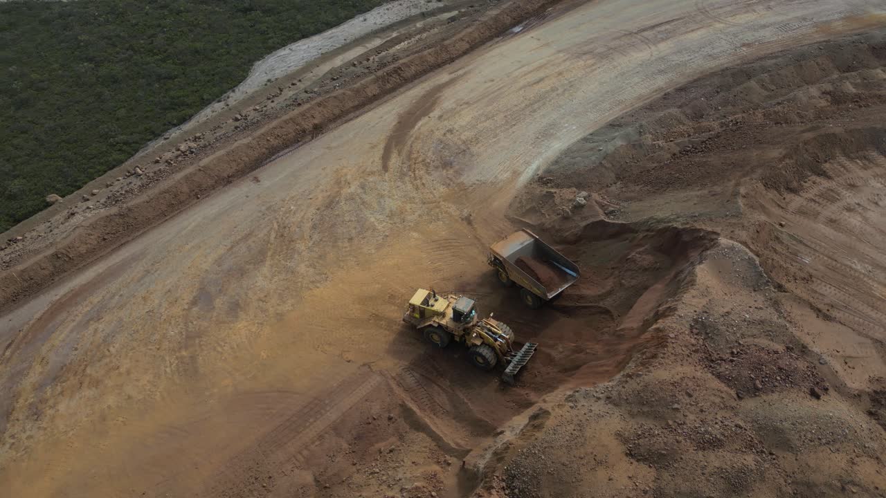 excavadora y camión trabajando en un sitio de minería de níquel moviendo tierra con pala