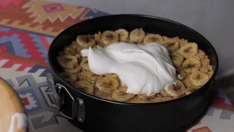 scooping cream on to a banoffee pie