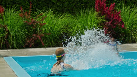 niños salpicándose en una piscina