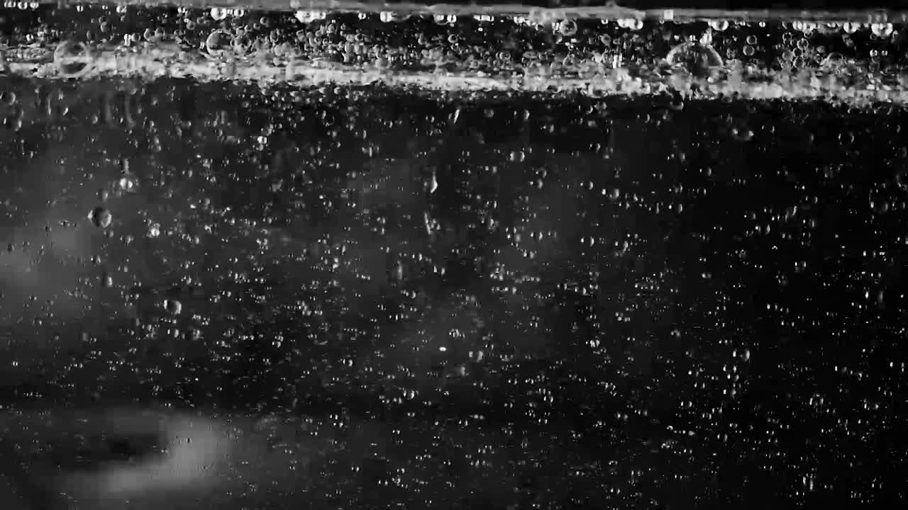 추상적인 디자인을 만드는 표면 거품이 있는 컨테이너로 투사되는 지저분한 투명한 액체 거품