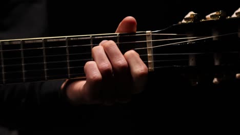 shot of guitarist hand moving up and down the neck of a guitar