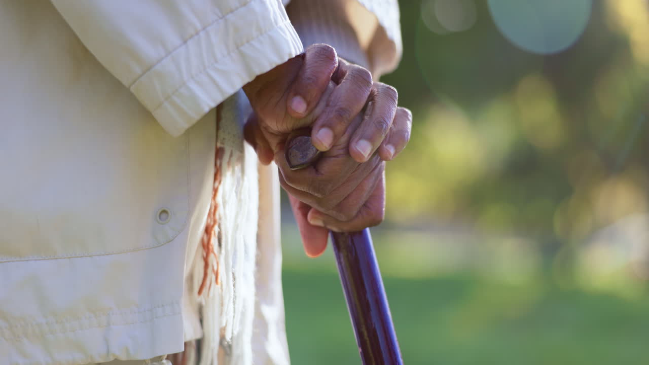 Anziano, all'aperto e mani su bastone da passeggio