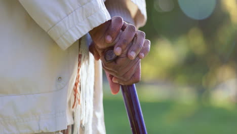persona de edad avanzada, al aire libre y manos en bastón