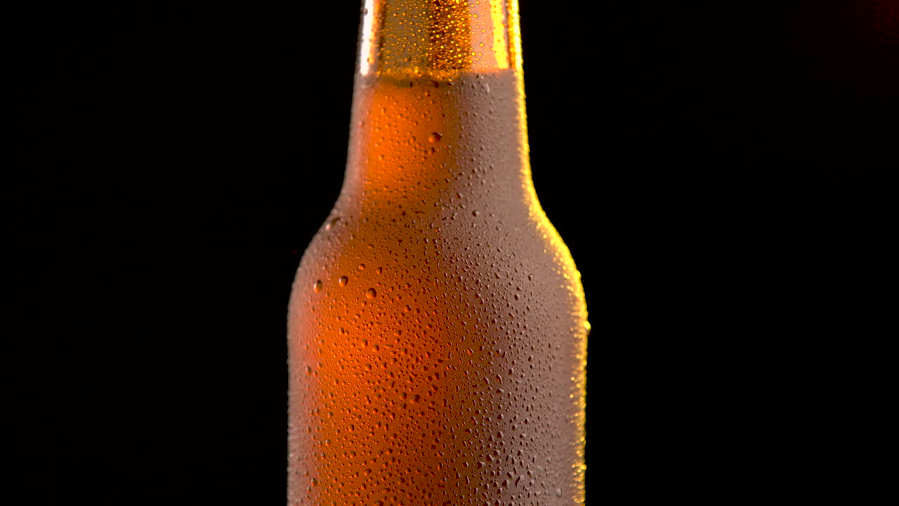 One beer bottle rotating on black background