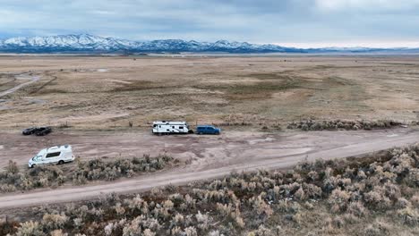 motorhome trailers over remote plains camping ground in utah, united states