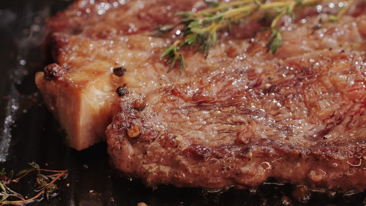 Fresh marbled beef with pepper, salt and rosemary close-up macro. Cooking juicy steak on grill with oil. Premium organic wagyu meat. High quality 4k footage