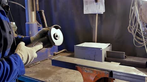 worker using angle grinder to cut metal