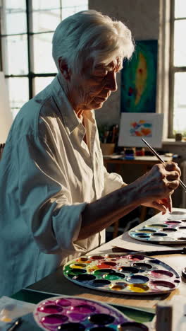 senior artist painting in studio
